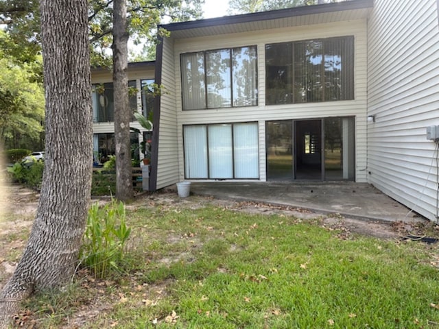 rear view of property with a yard and a patio area