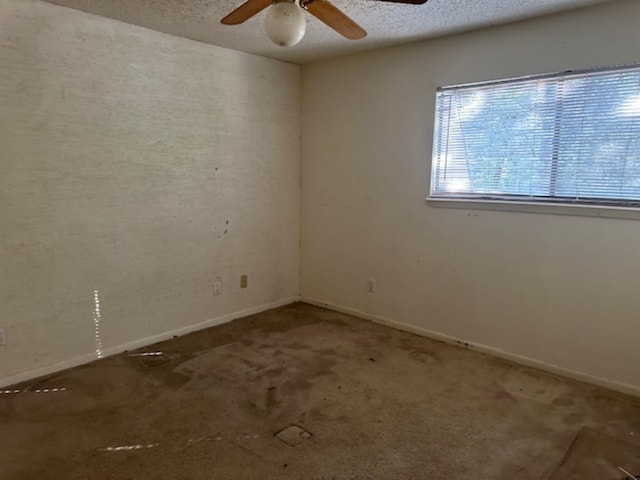 carpeted spare room with a textured ceiling and ceiling fan