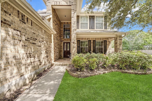 view of exterior entry with a yard