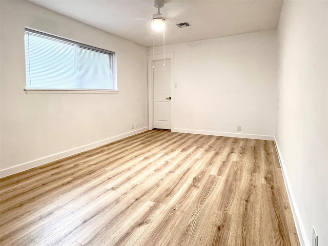 spare room featuring visible vents, baseboards, and light wood-style floors