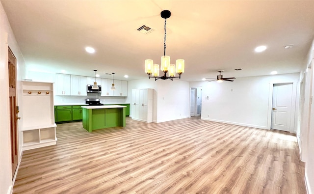 kitchen featuring visible vents, stainless steel microwave, a center island, light wood-style floors, and green cabinets