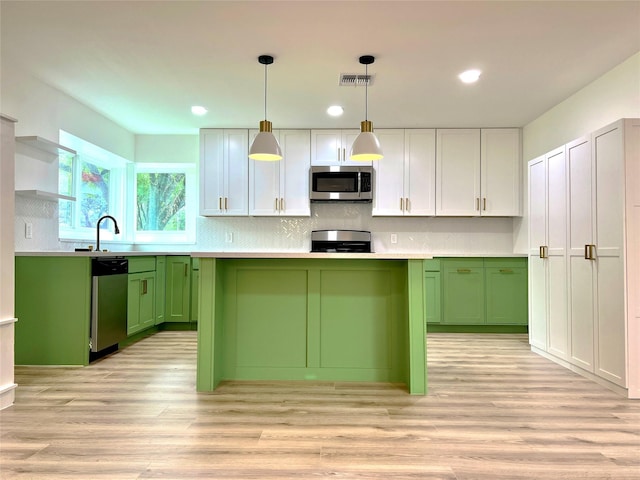 kitchen with visible vents, green cabinetry, light countertops, appliances with stainless steel finishes, and a sink