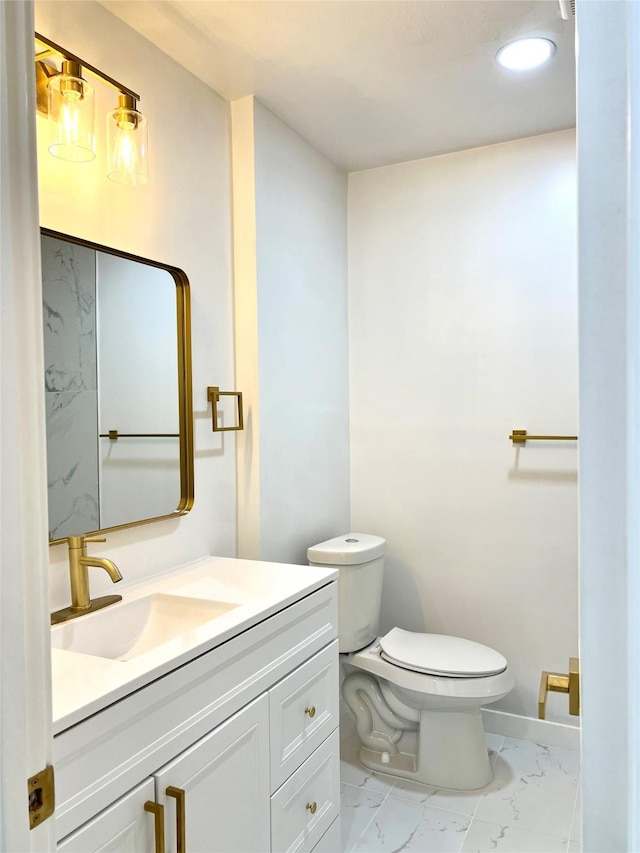 bathroom with baseboards, toilet, marble finish floor, and vanity