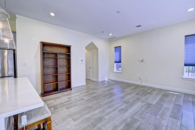 unfurnished living room featuring plenty of natural light and light wood-type flooring