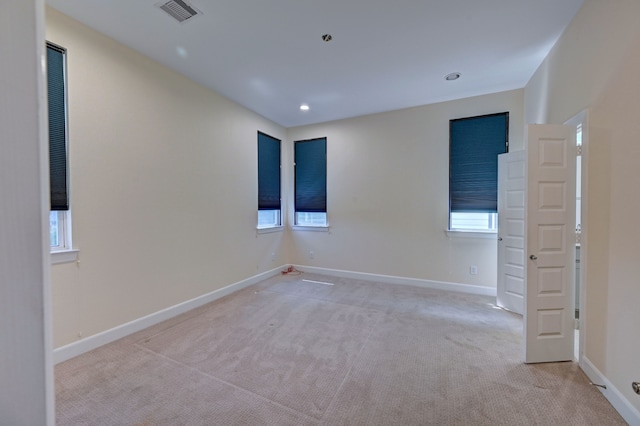 empty room featuring light carpet and plenty of natural light