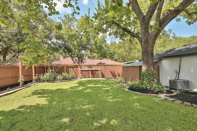 view of yard featuring central air condition unit, a fenced backyard, and a garden