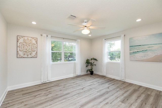 spare room with visible vents, wood finished floors, recessed lighting, baseboards, and ceiling fan