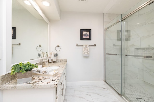 full bath featuring vanity, a shower stall, baseboards, and marble finish floor