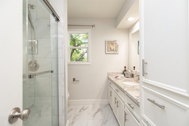 full bathroom with marble finish floor, vanity, a shower stall, and baseboards