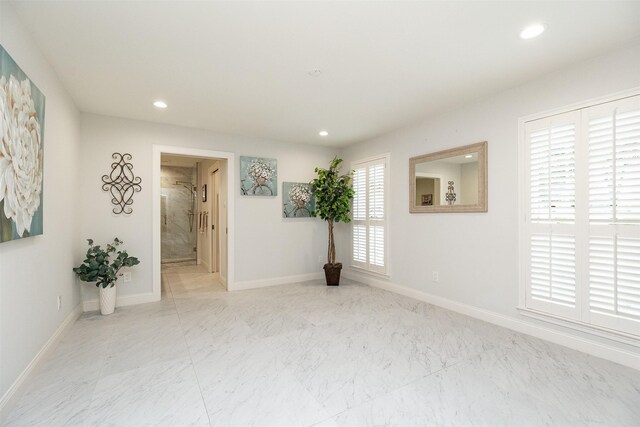 spare room featuring recessed lighting, baseboards, and marble finish floor