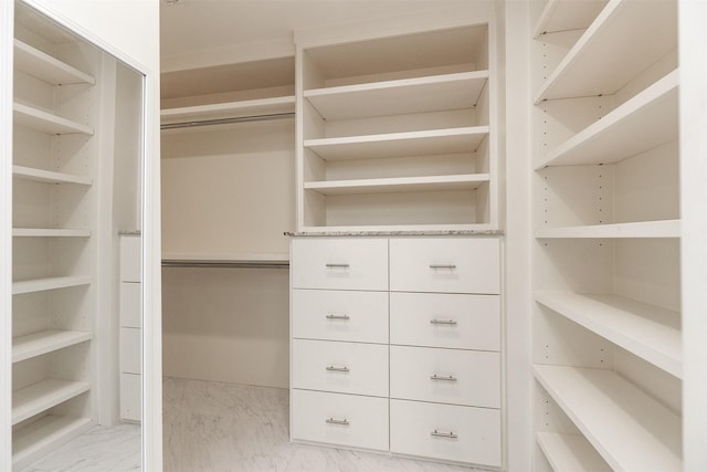 walk in closet featuring marble finish floor