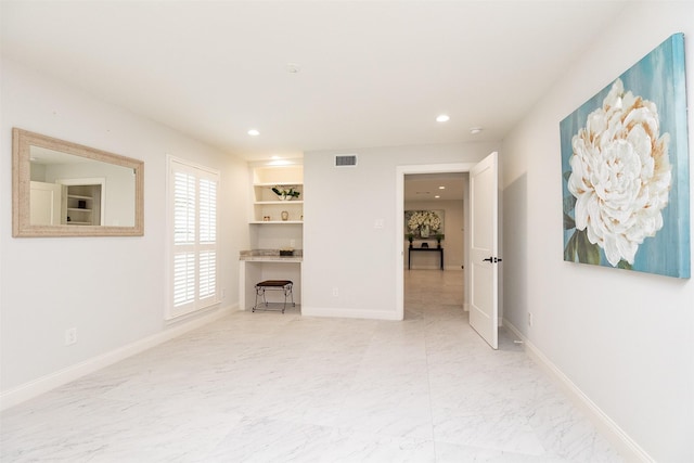 unfurnished living room featuring visible vents, marble finish floor, and baseboards