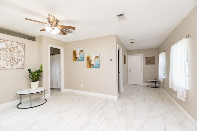 interior space with ceiling fan