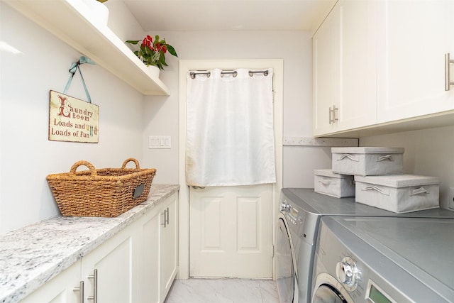 laundry area with washer and dryer, cabinet space, and marble finish floor