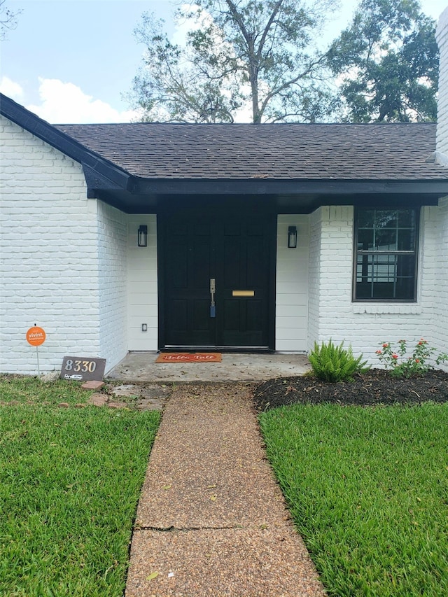 property entrance featuring a lawn