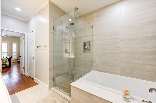 bathroom featuring crown molding, hardwood / wood-style floors, and separate shower and tub