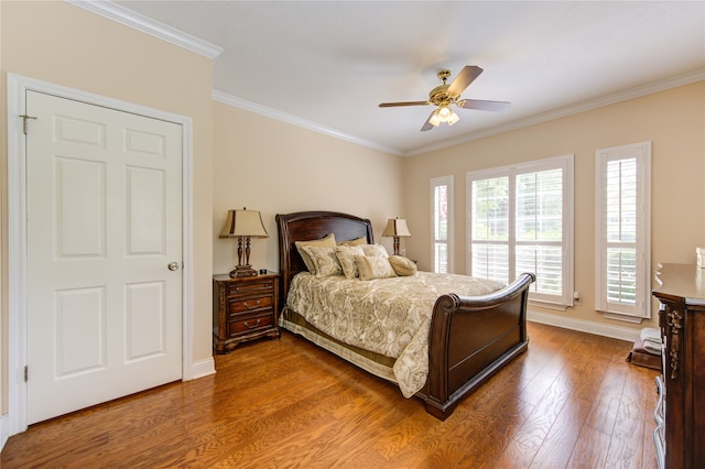 bedroom with crown molding, hardwood / wood-style floors, and ceiling fan