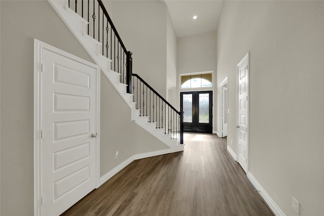 foyer featuring dark wood-type flooring, french doors, and a high ceiling