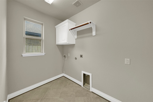 washroom featuring cabinets, electric dryer hookup, gas dryer hookup, light tile patterned floors, and washer hookup