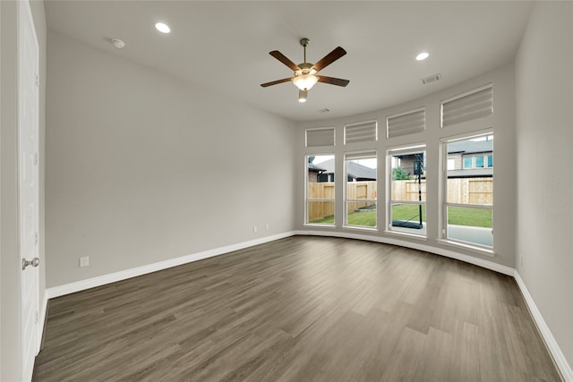 spare room featuring dark wood-type flooring and ceiling fan