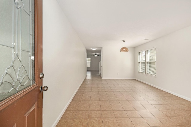 empty room with ceiling fan and light tile patterned floors