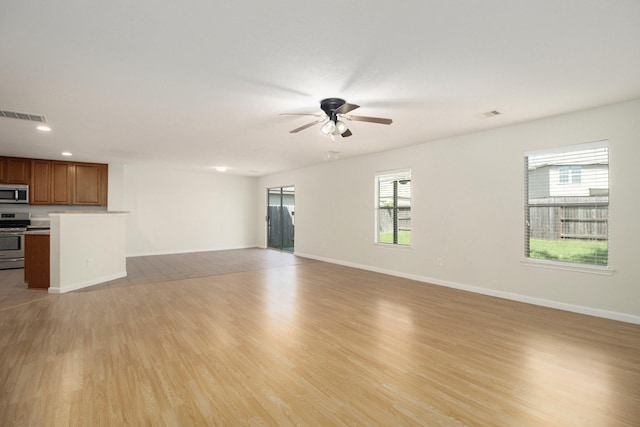 unfurnished living room featuring ceiling fan and light hardwood / wood-style flooring