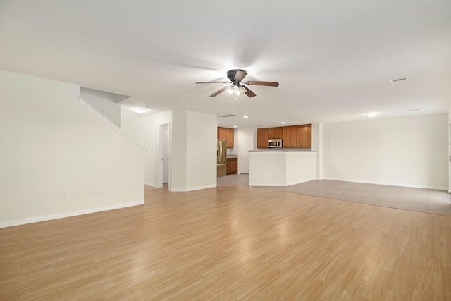 unfurnished living room featuring ceiling fan and light hardwood / wood-style flooring