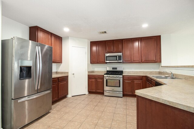 kitchen featuring sink, light tile patterned flooring, and appliances with stainless steel finishes