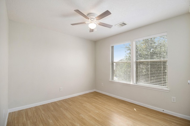 spare room with ceiling fan, a textured ceiling, and light wood-type flooring