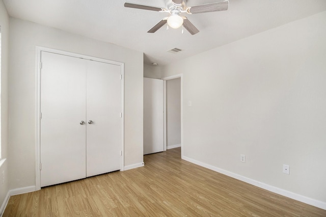 unfurnished bedroom with ceiling fan, a closet, and light hardwood / wood-style flooring