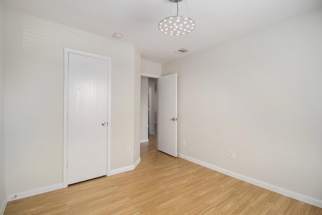 unfurnished bedroom featuring a closet and light hardwood / wood-style flooring