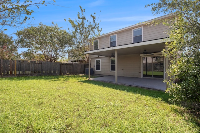 back of property with ceiling fan, a yard, and a patio