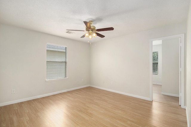 unfurnished room featuring a textured ceiling, light hardwood / wood-style floors, and ceiling fan