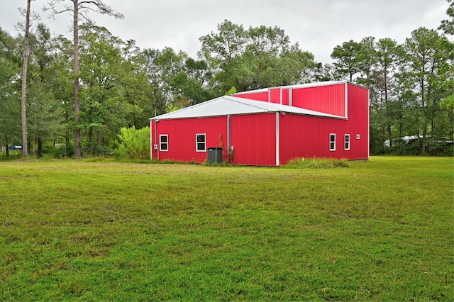 view of outdoor structure featuring a yard and central air condition unit