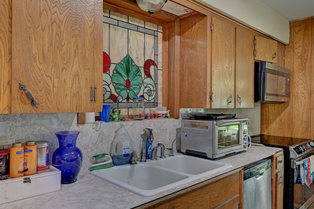 kitchen featuring appliances with stainless steel finishes, tasteful backsplash, and sink