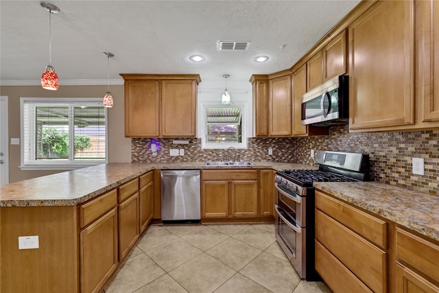 kitchen featuring ornamental molding, pendant lighting, stainless steel appliances, and sink