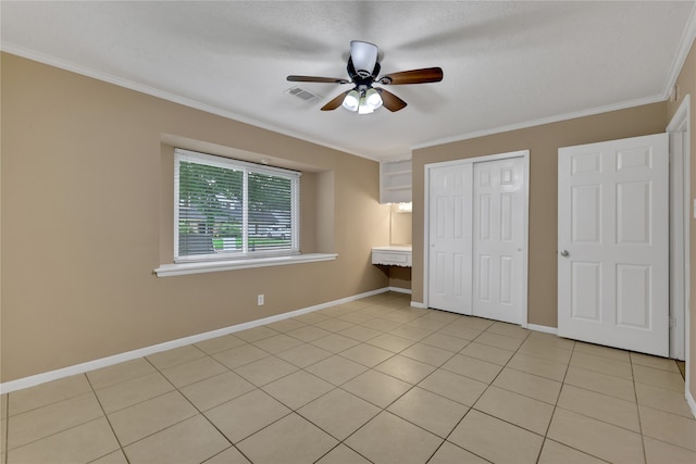 unfurnished bedroom with light tile patterned floors, ceiling fan, ornamental molding, and a closet