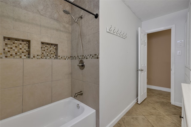 bathroom with a textured ceiling and tiled shower / bath