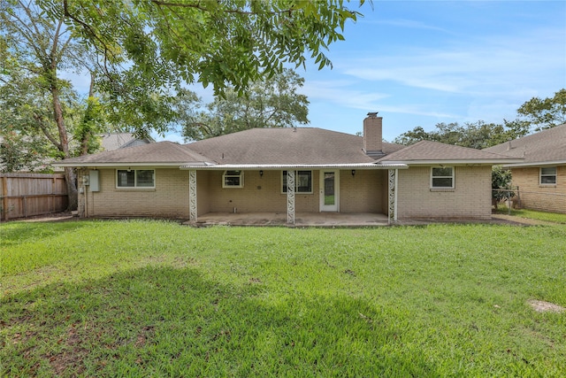 back of house with a lawn and a patio