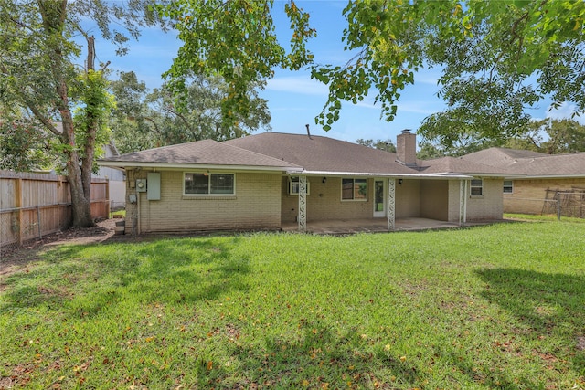 back of property featuring a yard and a patio