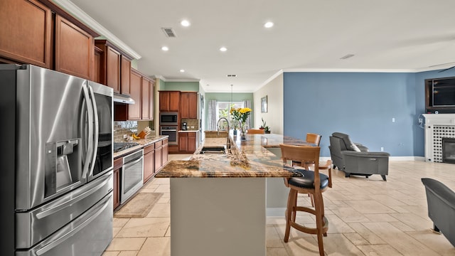 kitchen with a kitchen breakfast bar, a tile fireplace, a spacious island, backsplash, and stainless steel appliances