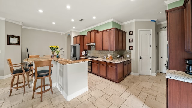 kitchen with a kitchen island with sink, light stone counters, appliances with stainless steel finishes, and decorative backsplash