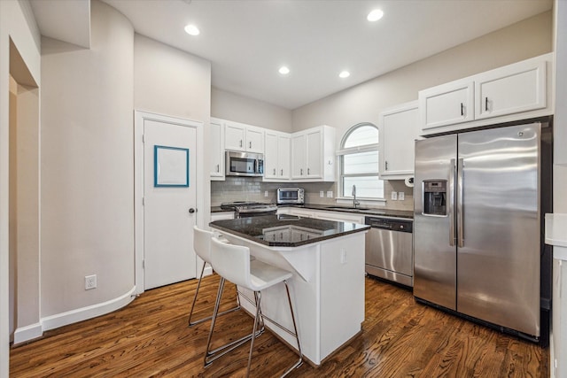 kitchen with sink, white cabinets, a kitchen breakfast bar, a center island, and stainless steel appliances