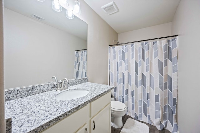 bathroom featuring curtained shower, vanity, and toilet