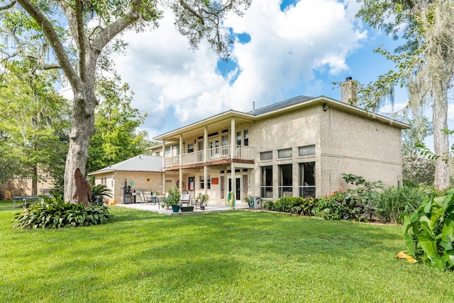 back of property featuring a balcony, a yard, and a patio