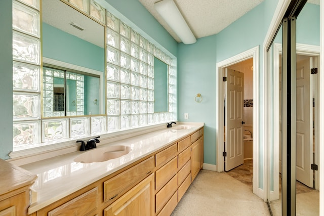 bathroom featuring a textured ceiling and vanity