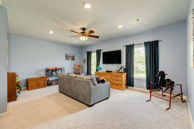 carpeted living room with a textured ceiling and ceiling fan