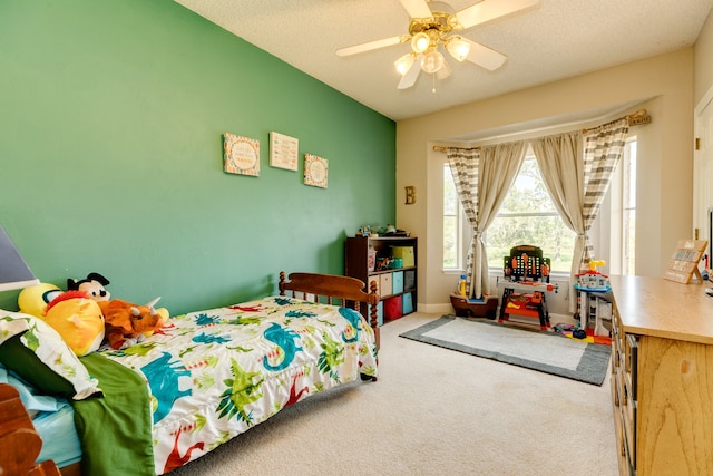 carpeted bedroom featuring a textured ceiling and ceiling fan