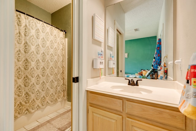 bathroom with a textured ceiling, vanity, tile patterned floors, and shower / bath combination with curtain