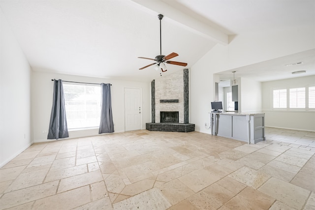 unfurnished living room featuring beam ceiling, ceiling fan, a fireplace, and a wealth of natural light